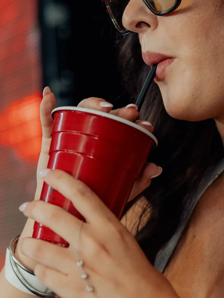 Festivalganger drinkt uit een rode beker