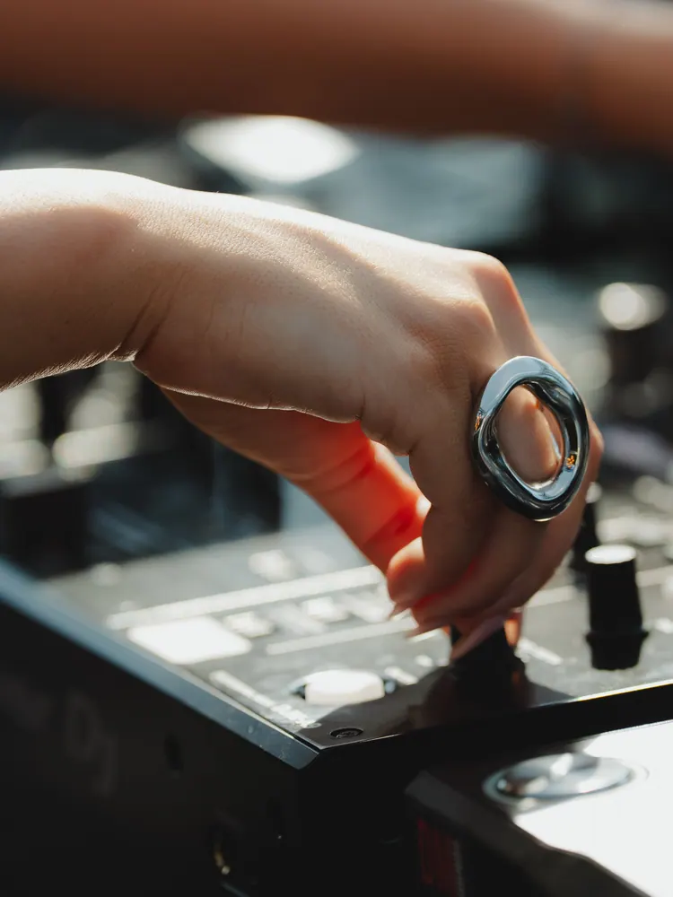 Hand met grote zilveren ring aan de mixer