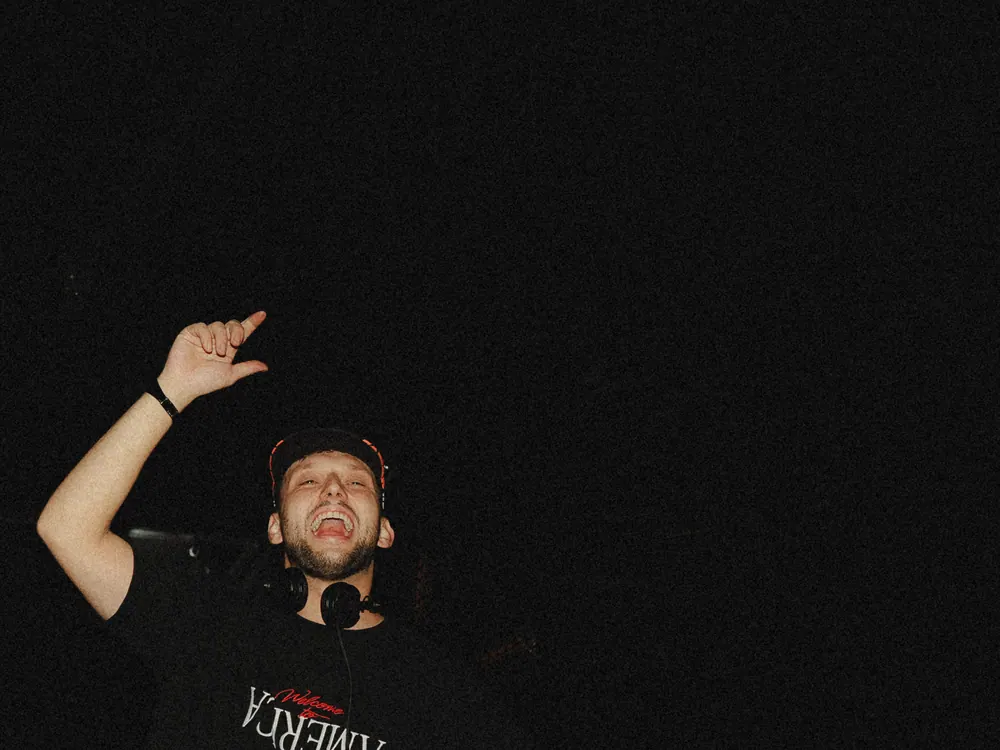 DJ steekt zijn hand op in het donker