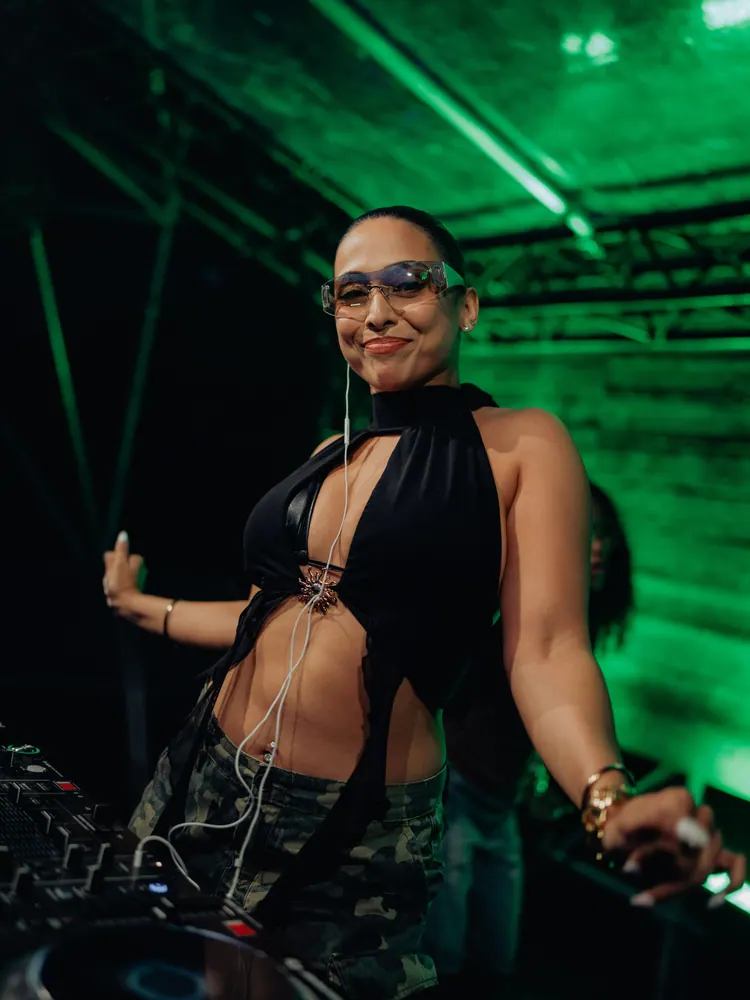 DJ lacht achter de draaitafel in groen licht
