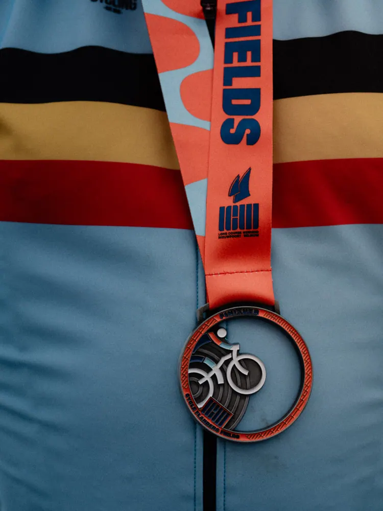 Finishermedaille met fietsje op een blauw sportshirt