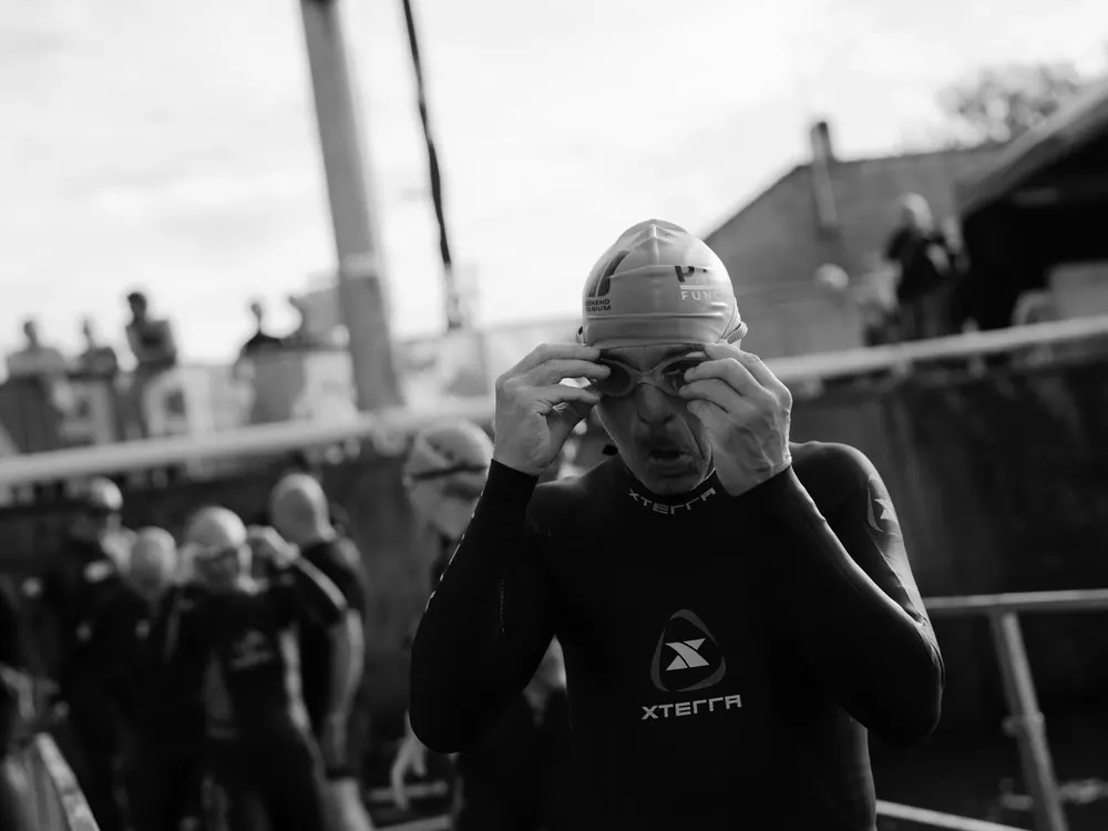 Zwemmer zet zijn zwembril op voor de start, in zwart-wit