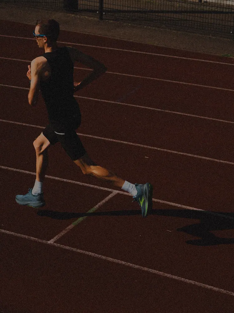 Hardloper in silhouet op een atletiekbaan