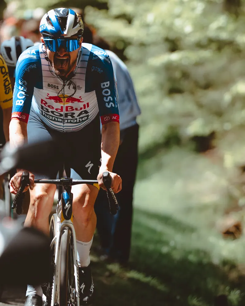 Renner van Red Bull klimt tussen het groen tijdens Liège–Bastogne–Liège