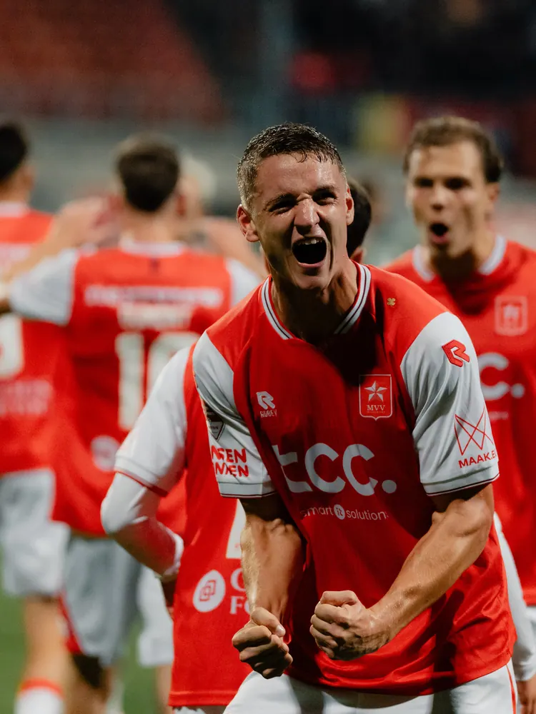 MVV-speler schreeuwt het uit na een goal tegen Helmond Sport, ploeggenoten juichen erachter