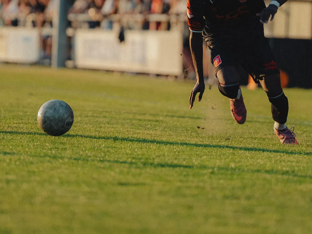 Bal op het gras en de voeten van een speler