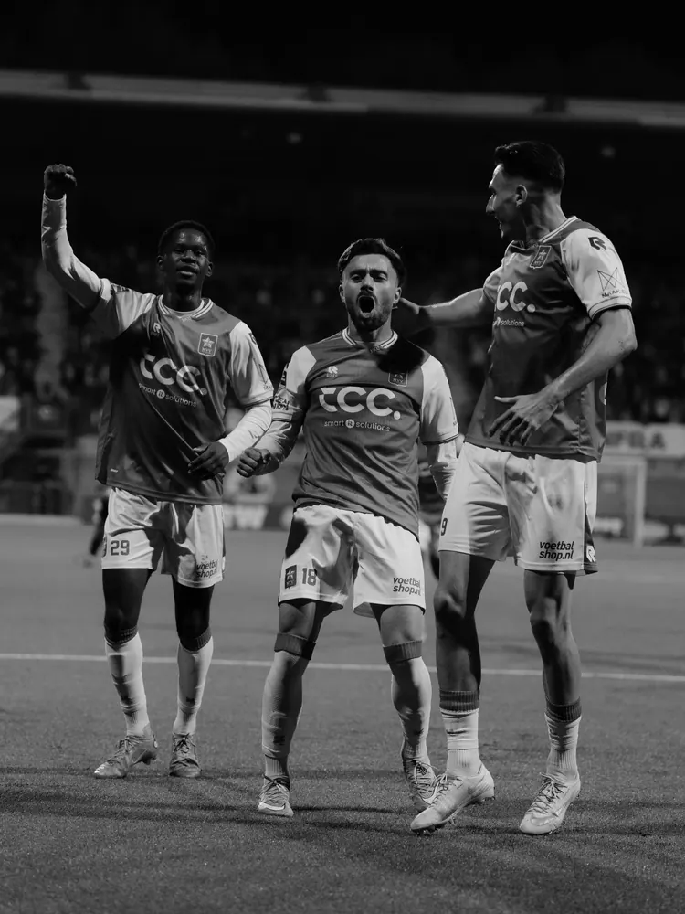 MVV-spelers vieren een goal, in zwart-wit