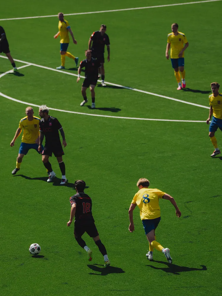 Spelers in het geel op het veld van bovenaf