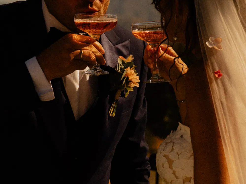 Bruidspaar proost met champagne in warm avondlicht