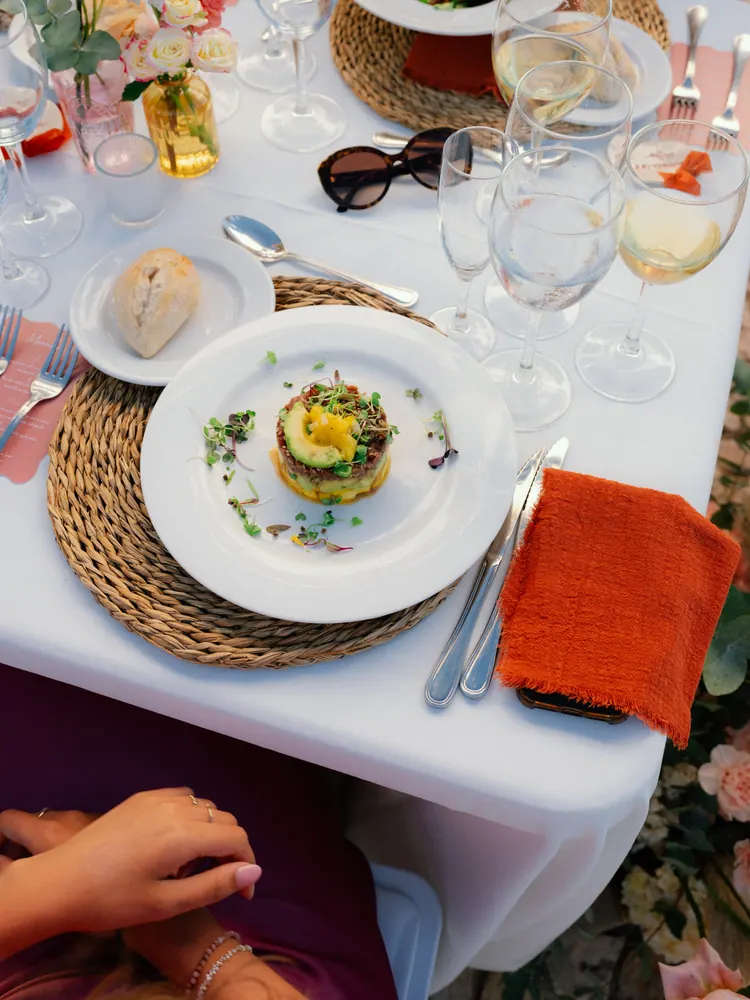 Gedekte tafel met voorgerecht en oranje servet, van bovenaf