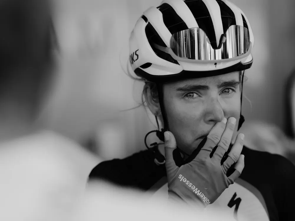 Renster van VolkerWessels houdt haar hand voor haar mond, ontroerd na de finish, in zwart-wit