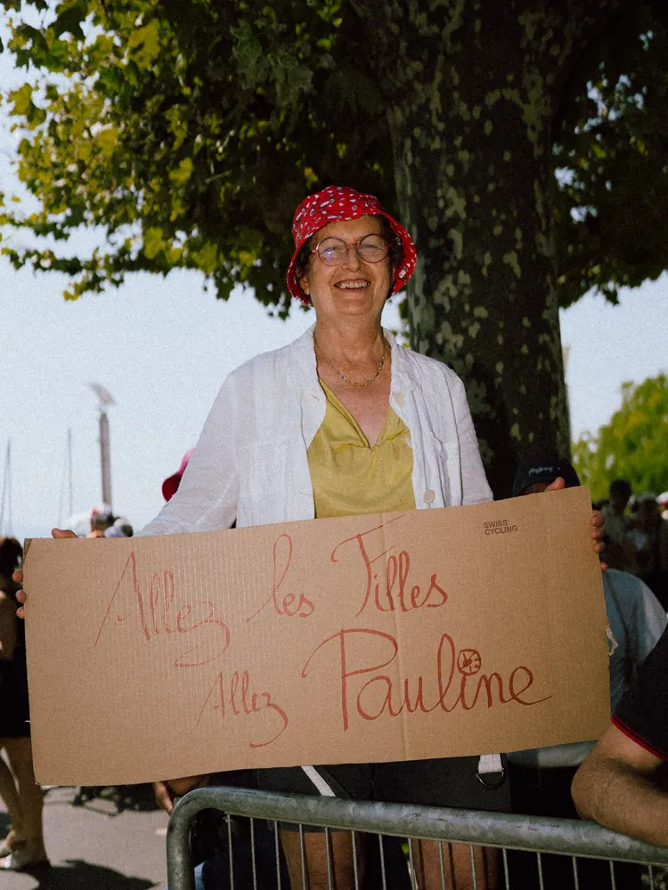 Supporter met een kartonnen bord 'Allez les filles, allez Pauline' langs het parcours