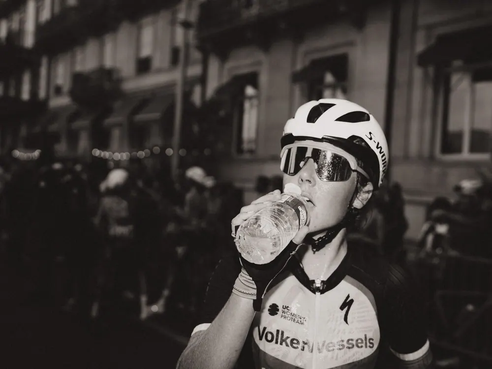 Renster van VolkerWessels drinkt water na de finish, in zwart-wit