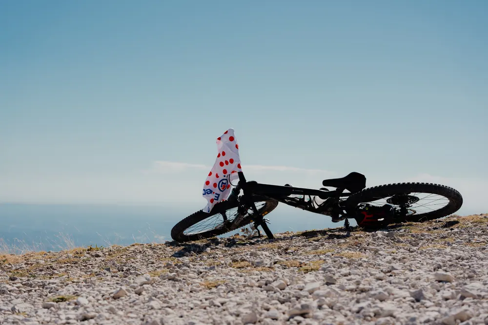 Fiets met bolletjesmotief ligt tussen de stenen van de Mont Ventoux